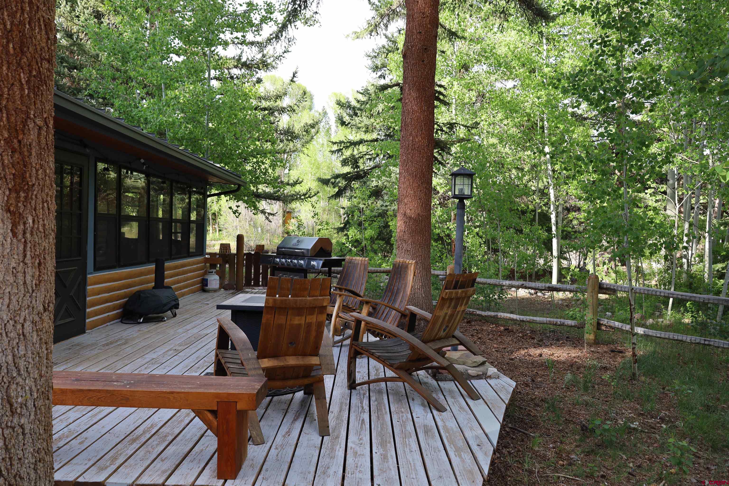 95 Deerpath Lane, Unit RIVERFRONT Almont, CO 81210 - Photo 7 of 35 a view of a patio with a table chairs and a backyard