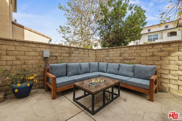a view of a patio with couches and a fire pit and a barbeque