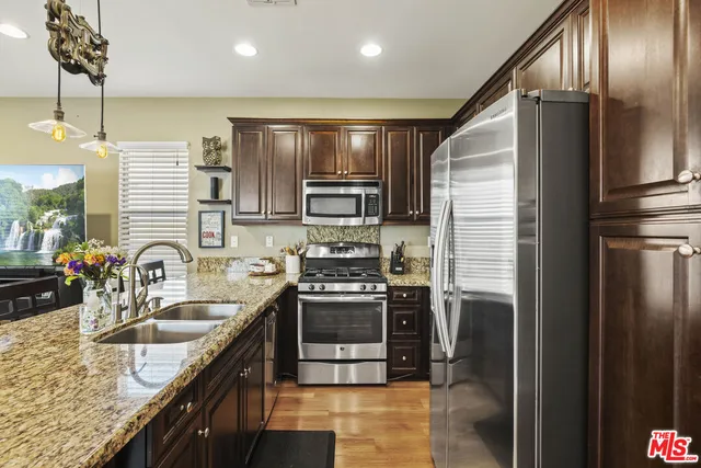 a kitchen with stainless steel appliances granite countertop a sink stove and refrigerator