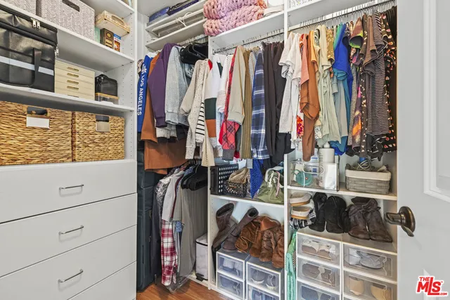 a view of walk in closet with clothes and shoes