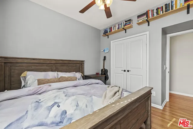a bedroom with a bed and wooden floor