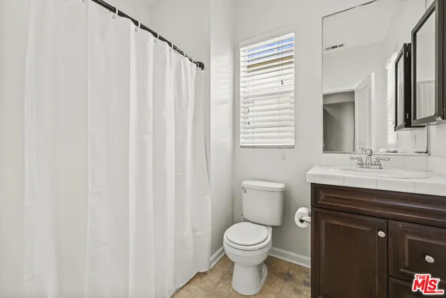a bathroom with a toilet a sink and a mirror