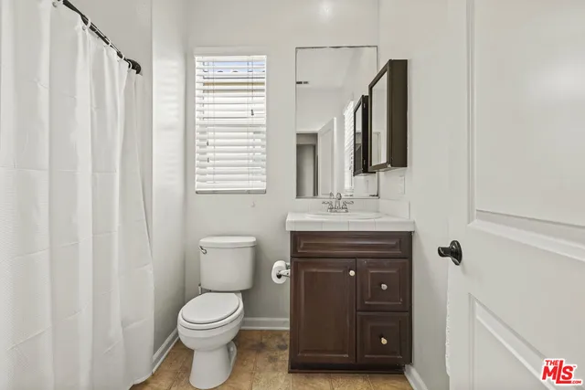 a bathroom with a toilet a sink a vanity and mirror