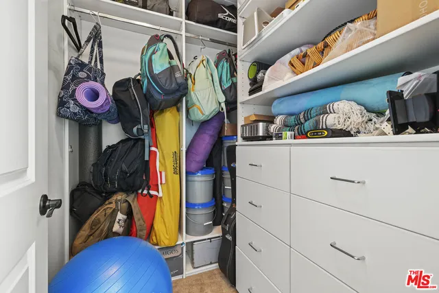a view of walk in closet with clothes and shoes