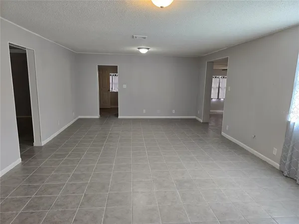 a view of an empty room with window and bathroom
