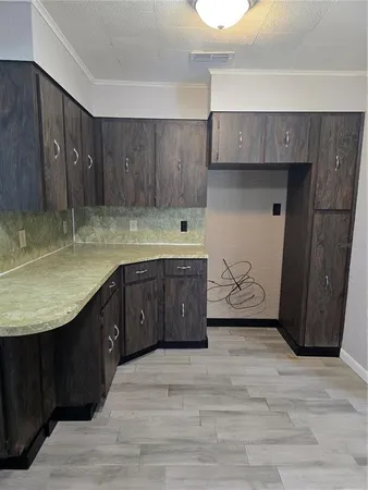 a kitchen with a sink a cabinets and wooden floor