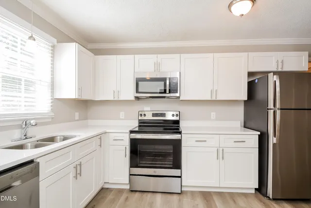 a kitchen with white cabinets and stainless steel appliances