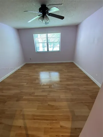 en empty room with windows and ceiling fan
