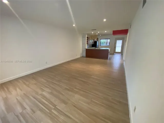 a view of kitchen and hall with wooden floor