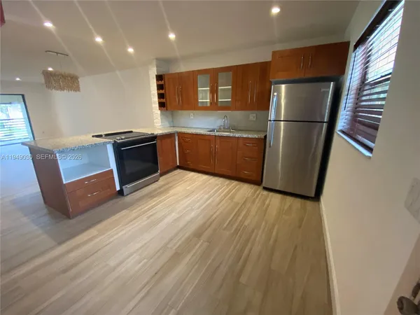 a kitchen with stainless steel appliances granite countertop a refrigerator a sink a stove a microwave and island
