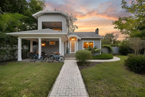 a view of a house with a yard and potted plants
