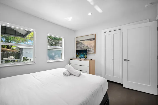 a bedroom with two beds and potted plant