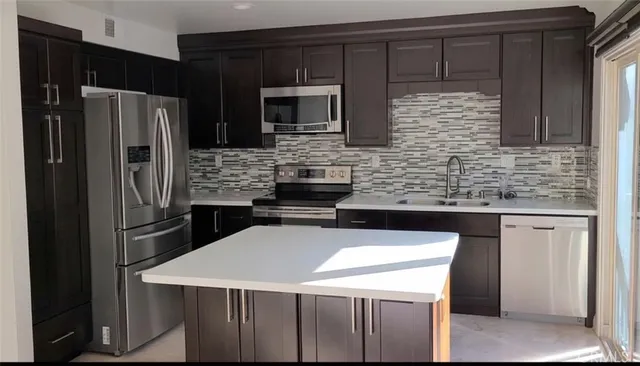 a kitchen with stainless steel appliances a sink and a refrigerator