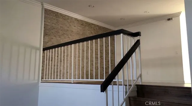a view of staircase with railing and white walls