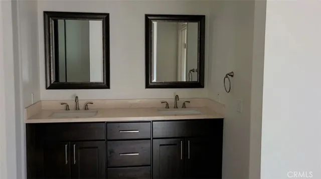 a bathroom with double sink and two mirror