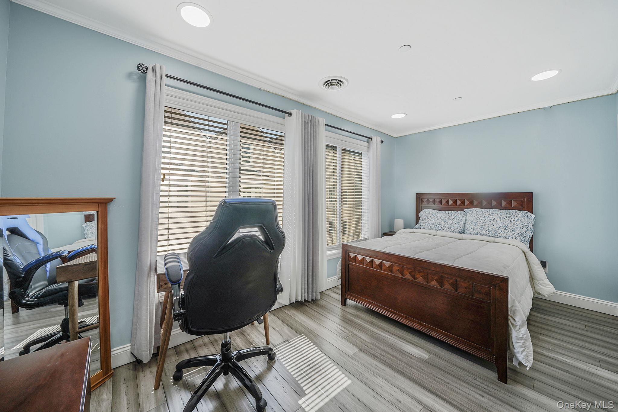 531 Ray Street, Unit 10 Freeport, NY 11520 - Photo 16 of 32 a bedroom with a bed and wooden floor