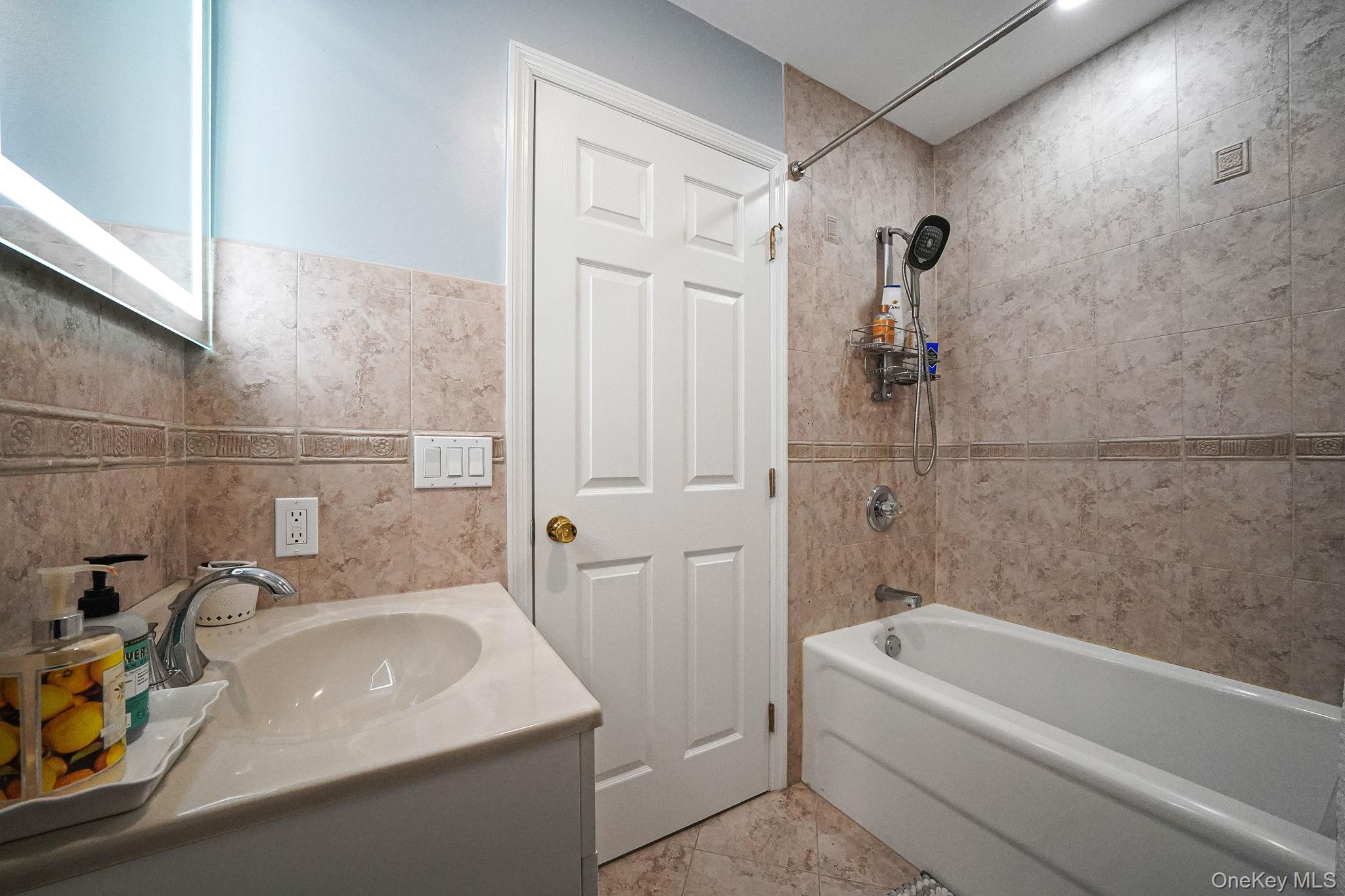 531 Ray Street, Unit 10 Freeport, NY 11520 - Photo 19 of 32 a bathroom with a sink a bathtub and a shower
