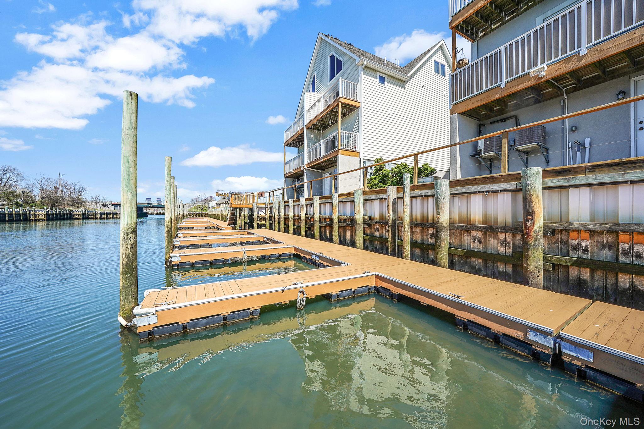 531 Ray Street, Unit 10 Freeport, NY 11520 - Photo 24 of 32 a small white house with a large pool and lawn chairs