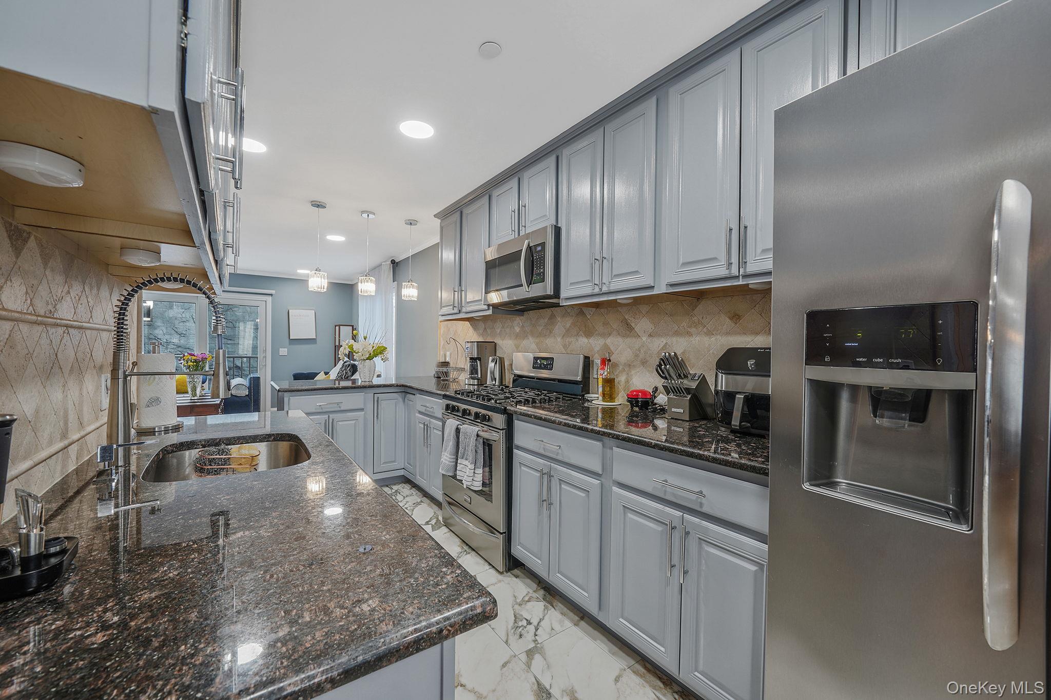 531 Ray Street, Unit 10 Freeport, NY 11520 - Photo 4 of 32 a kitchen with granite countertop a stove a sink and a refrigerator