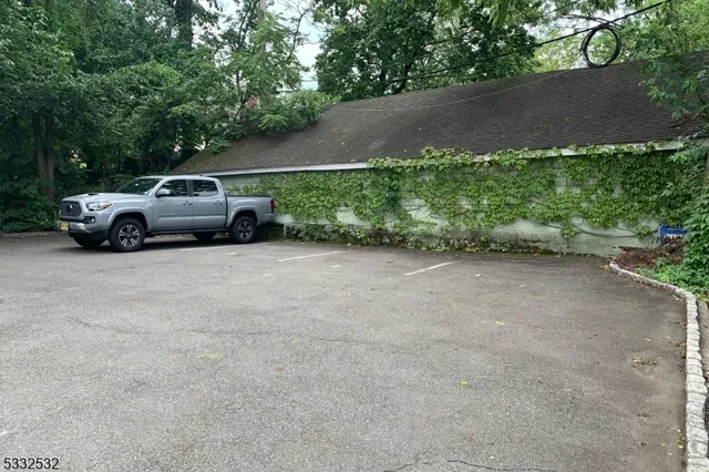 a view of car parked in parking lot with trees