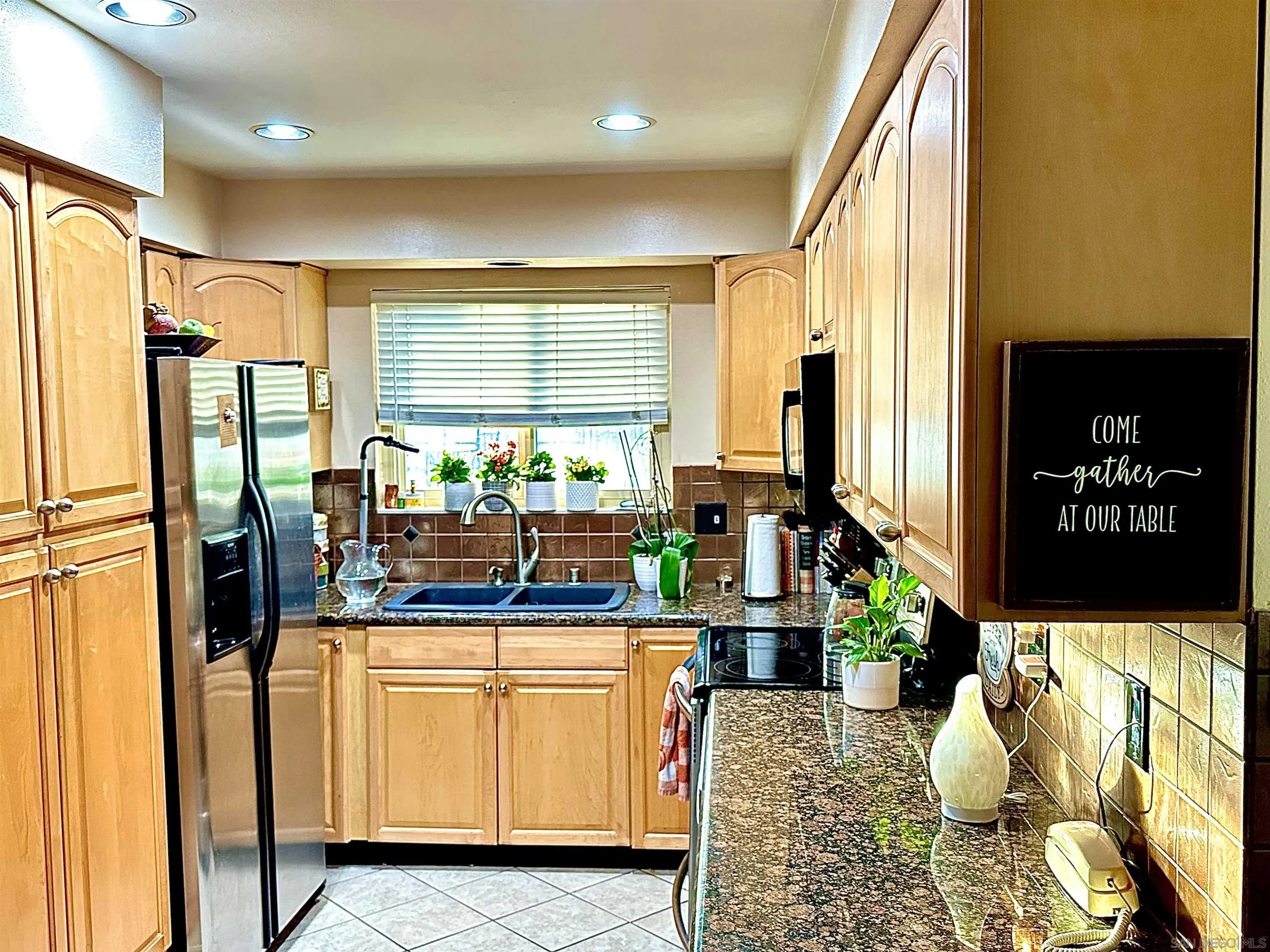 3684 Bartlett Avenue Oceanside, CA 92057 - Photo 5 of 38 a kitchen with stainless steel appliances kitchen island granite countertop a refrigerator and a counter space