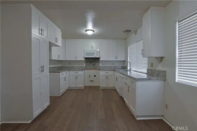 a kitchen with stainless steel appliances sink cabinets and window