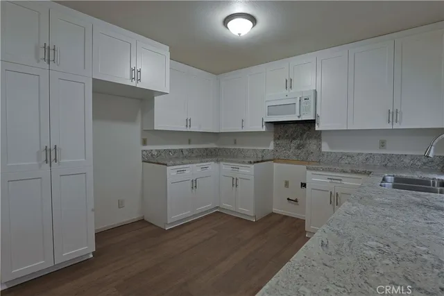 a kitchen with cabinets appliances and a wooden floor