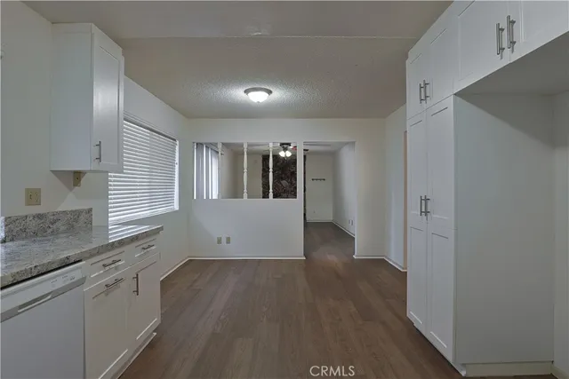 a view of a kitchen with wooden floor and electronic appliances