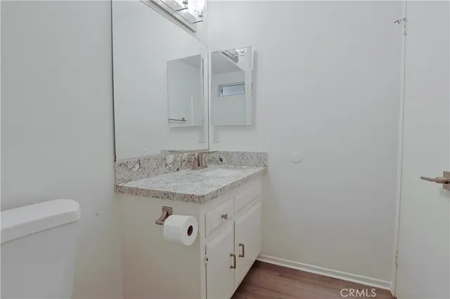 a bathroom with a granite countertop toilet sink and mirror