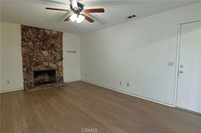 a view of empty room with fan and fireplace