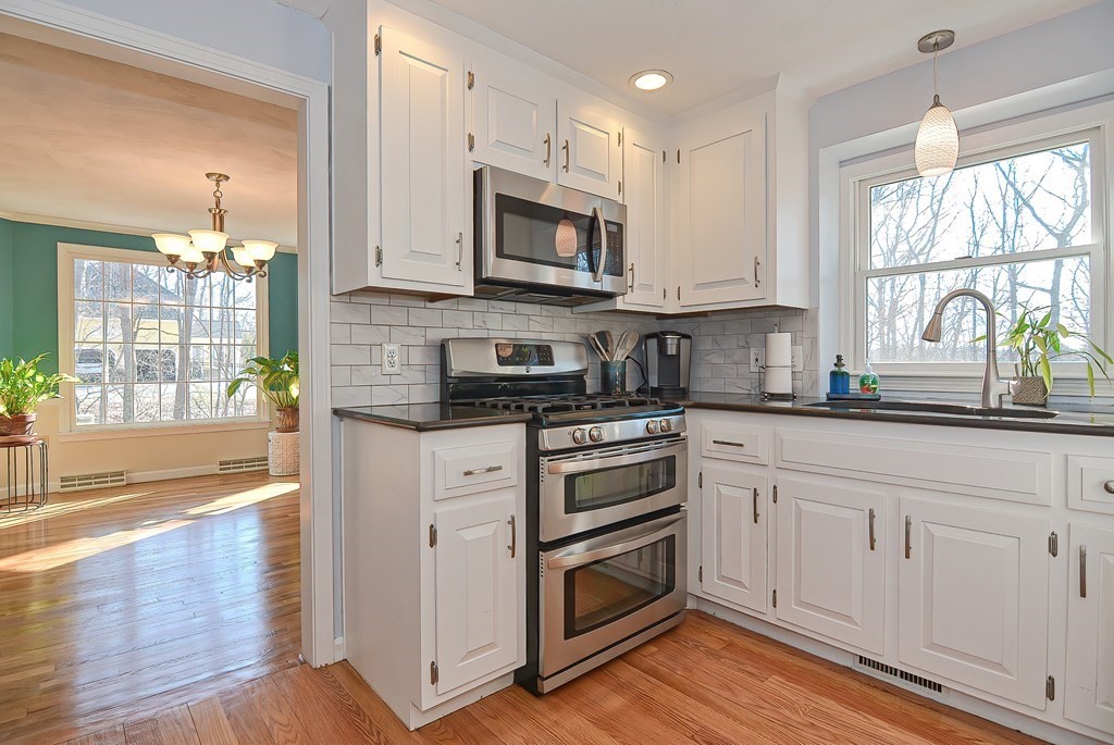 3 Jackson Circle Franklin, MA 02038 - Photo 3 of 25 a kitchen with stainless steel appliances granite countertop a stove a sink and a microwave