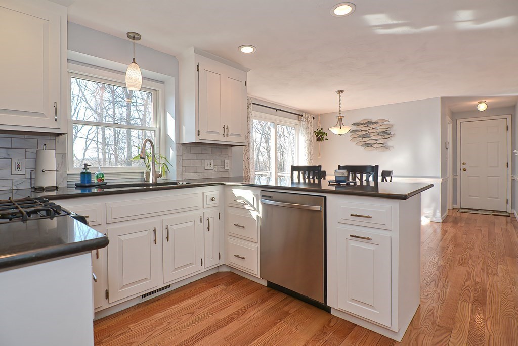 3 Jackson Circle Franklin, MA 02038 - Photo 4 of 25 a kitchen with granite countertop white cabinets white appliances a sink and wooden floor