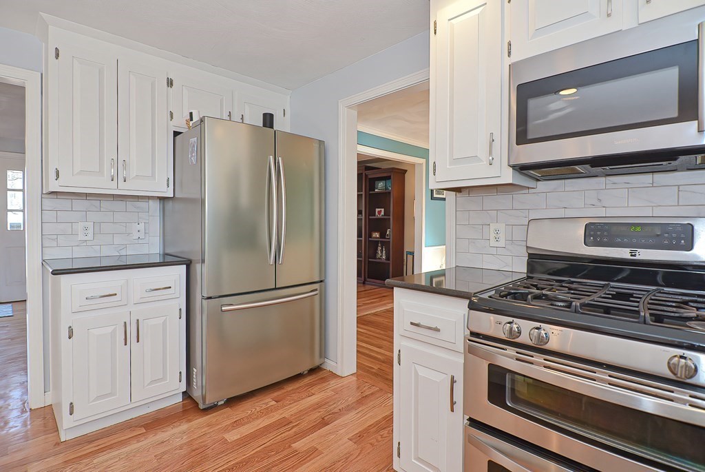 3 Jackson Circle Franklin, MA 02038 - Photo 5 of 25 a kitchen with granite countertop a refrigerator stove and microwave