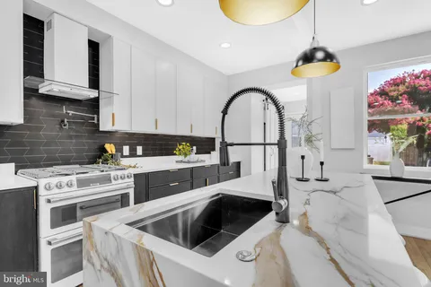 a kitchen with a stove a sink and a microwave