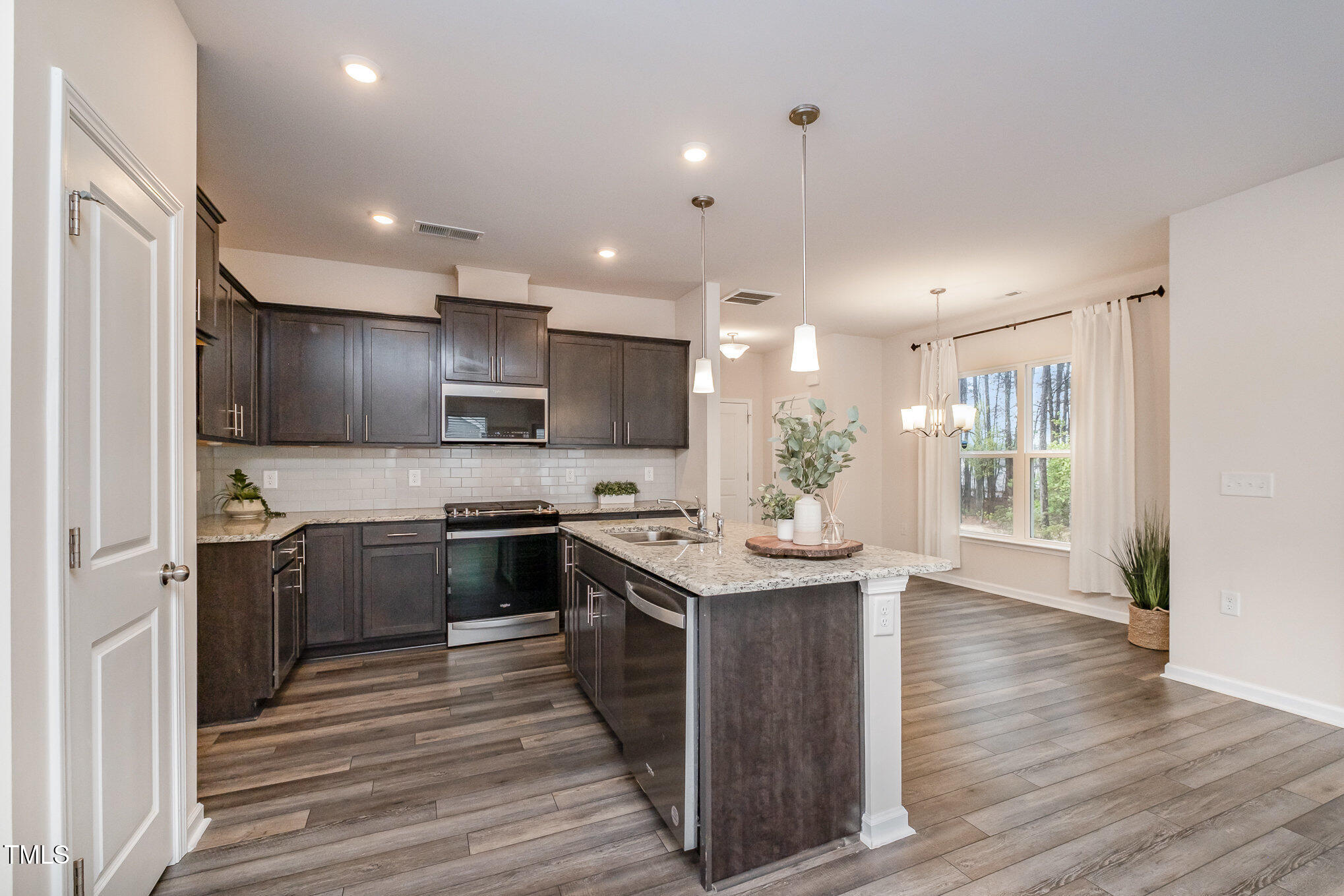 4220 Congleton Place Durham, NC 27703 - Photo 12 of 35 a kitchen with stainless steel appliances granite countertop a stove top oven a sink and a refrigerator