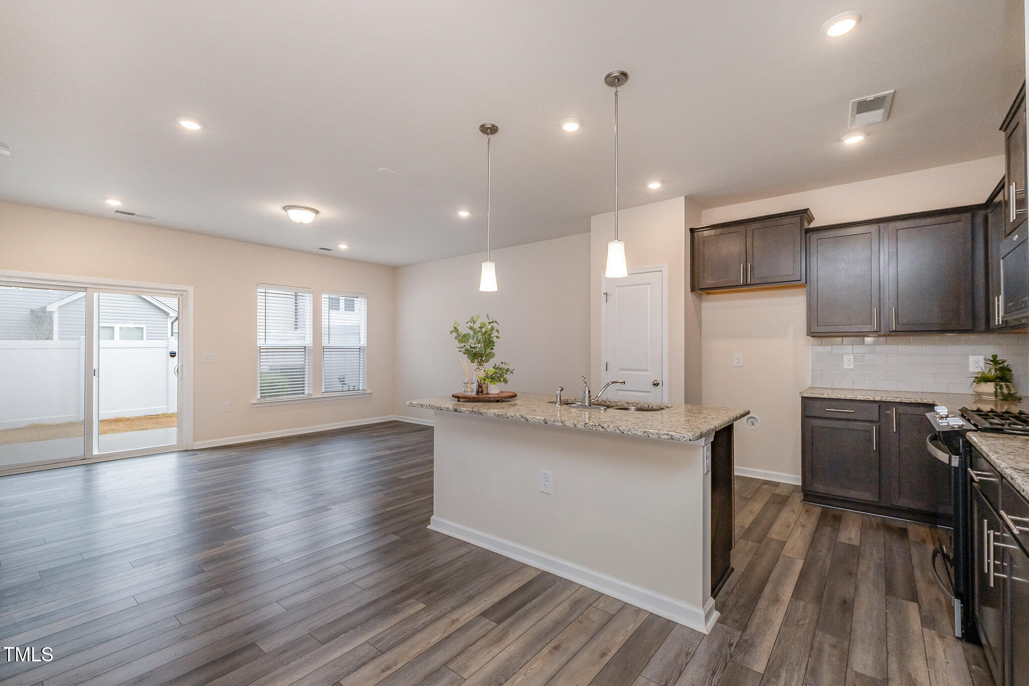 4220 Congleton Place Durham, NC 27703 - Photo 13 of 35 a kitchen with stainless steel appliances granite countertop a sink stove and wooden floor