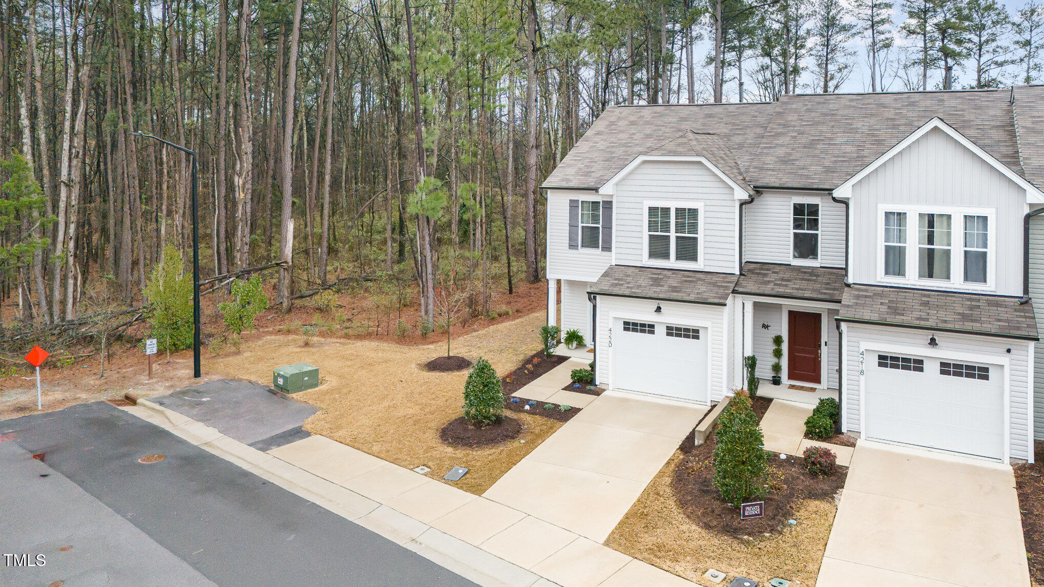 4220 Congleton Place Durham, NC 27703 - Photo 29 of 35 a view of a white house with a large windows and a yard with plants and large trees