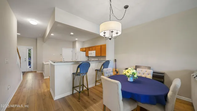 a view of a dining room with furniture a chandelier and wooden floor