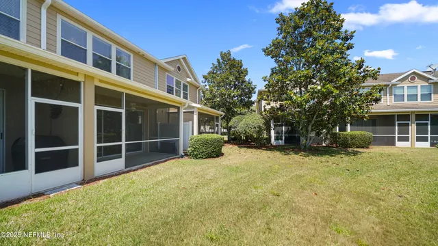 an aerial view of residential houses with outdoor space and lake view