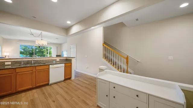 a kitchen with granite countertop a microwave a stove and white cabinets