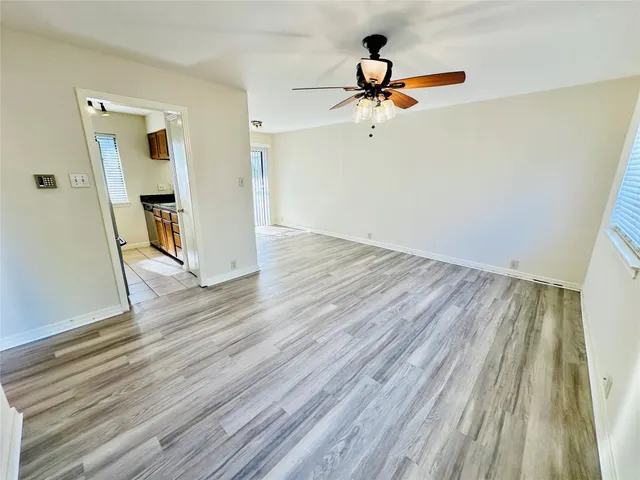 a view of room with wooden floor and ceiling fan