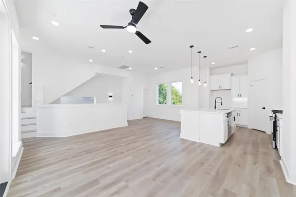 a view of a kitchen with kitchen island a sink stainless steel appliances and cabinets
