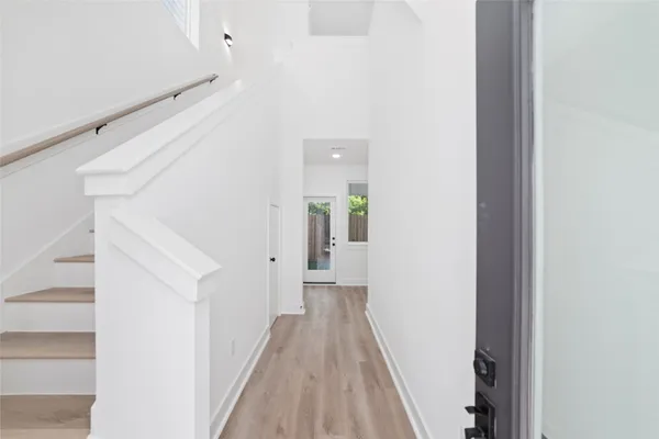 a view of a hallway with wooden floor and entryway