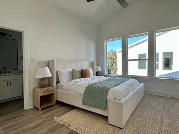 a spacious bedroom with a bed and a flat screen tv