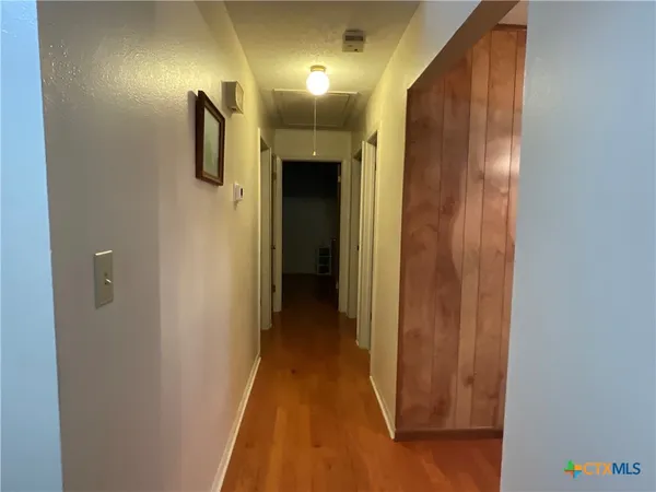 a view of a hallway with wooden floor