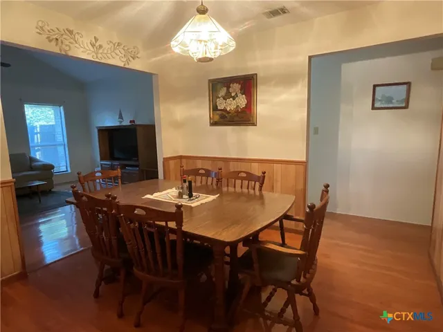 a view of a dining room with furniture wooden floor and a chandelier