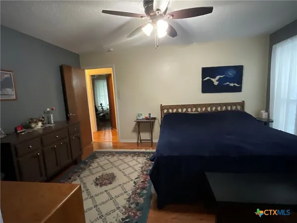 a bed sitting in a bedroom next to a window and a chandelier