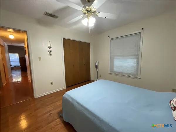 a bedroom with a bed and a chandelier fan