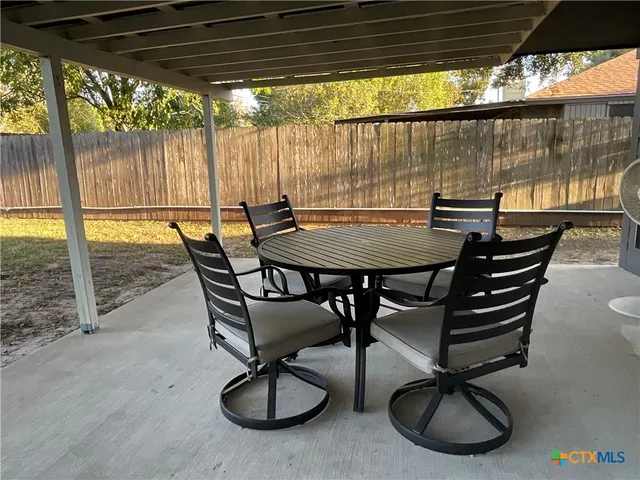 a view of a swimming pool with a table and chairs in the patio