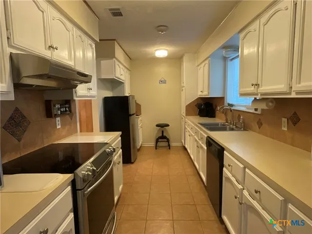 a kitchen with stainless steel appliances a sink and a refrigerator